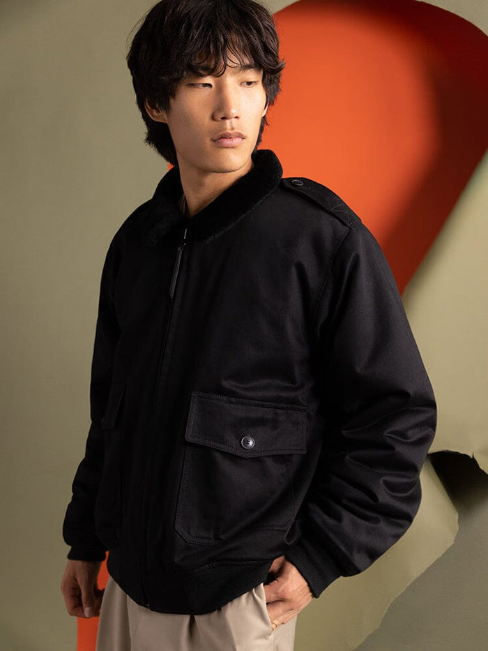 An individual wearing the 1940s B-10 Bomber Jacket by Alpha Industries in black.