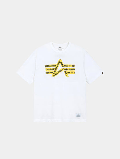 Alpha Caution Tape Tee by Alpha Industries is a white short-sleeve t-shirt with a yellow caution tape graphic and logo text on front.