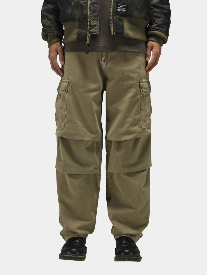 Alpha Industries Bdu Cargo Pant with side pockets, black shoes, dark camo jacket.