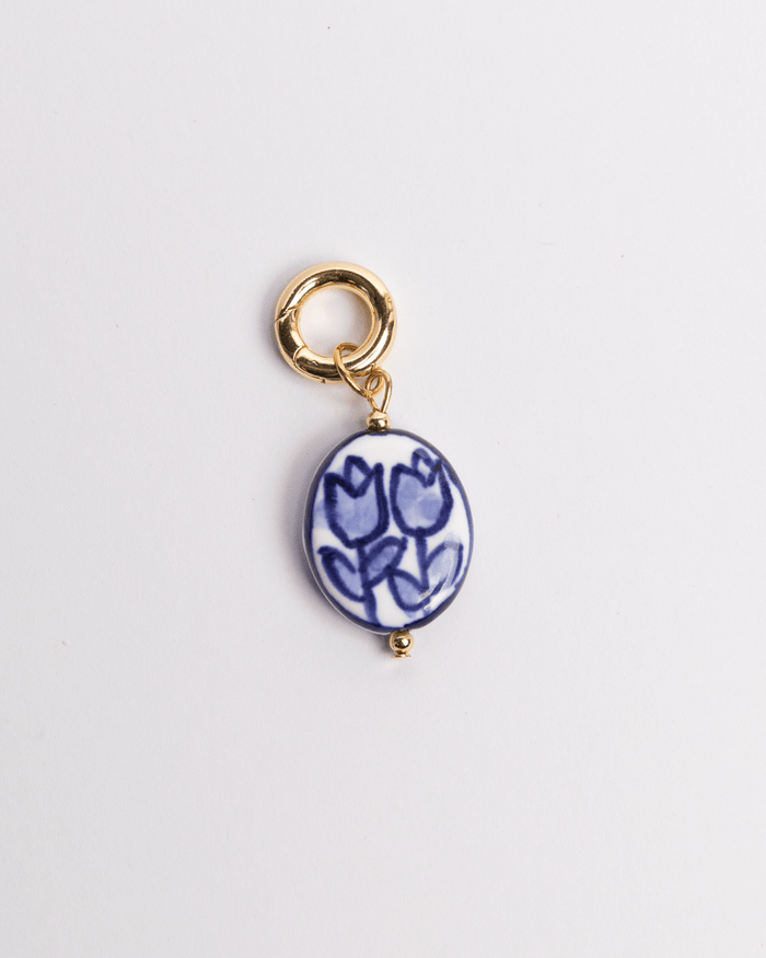 A painted blue tulip-shaped charm with a gold-colored clasp.