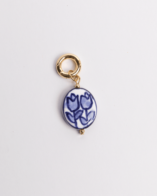 A painted blue tulip-shaped charm with a gold-colored clasp.