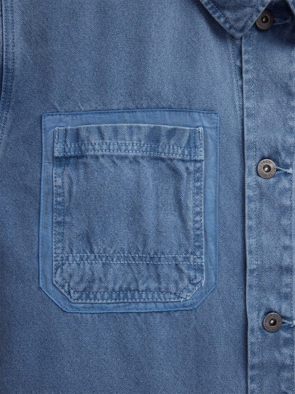 Alpha Industries CTN Chore Coat, blue denim cotton jacket with garment-washed finish, chest pocket with visible stitching, metal buttons down the placket.