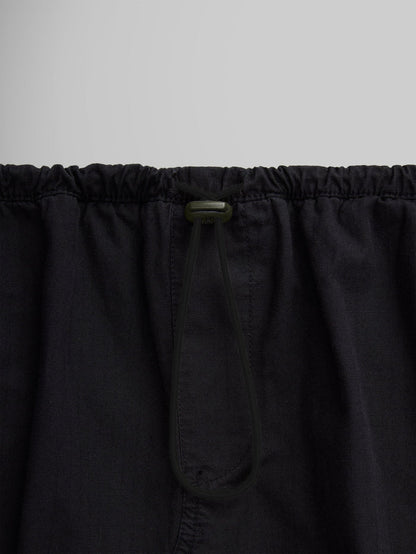 Close-up of the Women's Drawcord Skirt by Alpha Industries, showcasing its black fabric with a bungee waistband and drawstring tied in a loop.