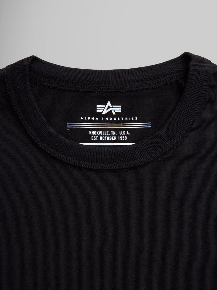 Black Alpha Industries Essential Tee collar and label with brand logo and establishment details.