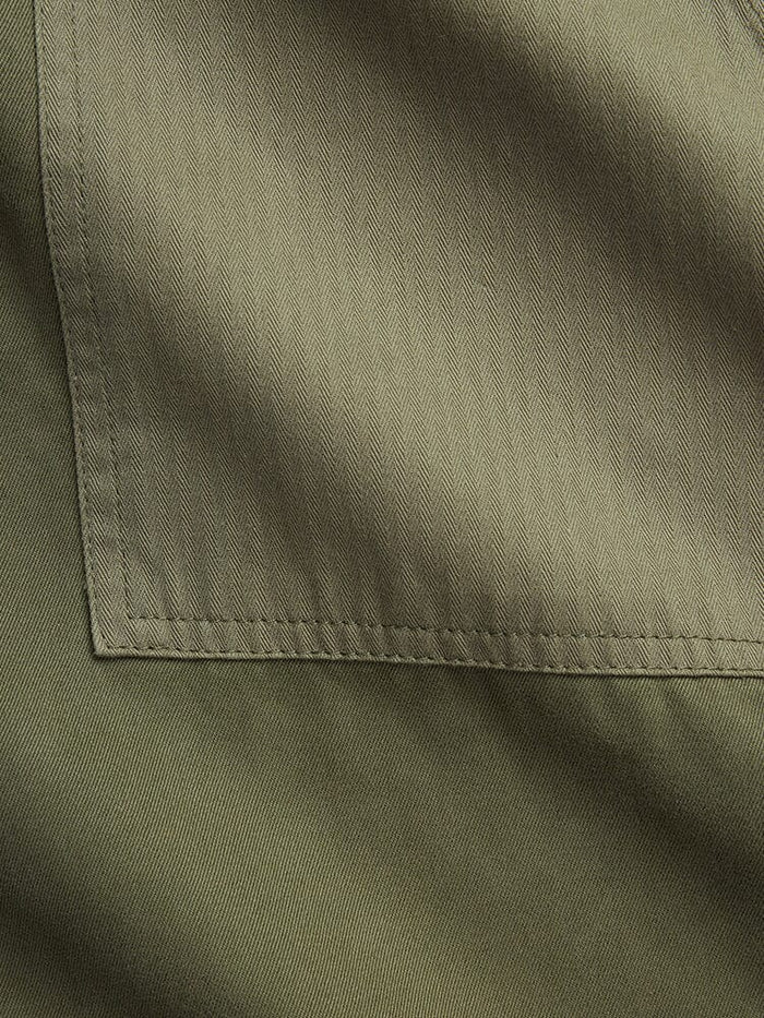 Alpha Industries Fatigue Pant, olive green cotton, visible pocket stitching, herringbone pattern.