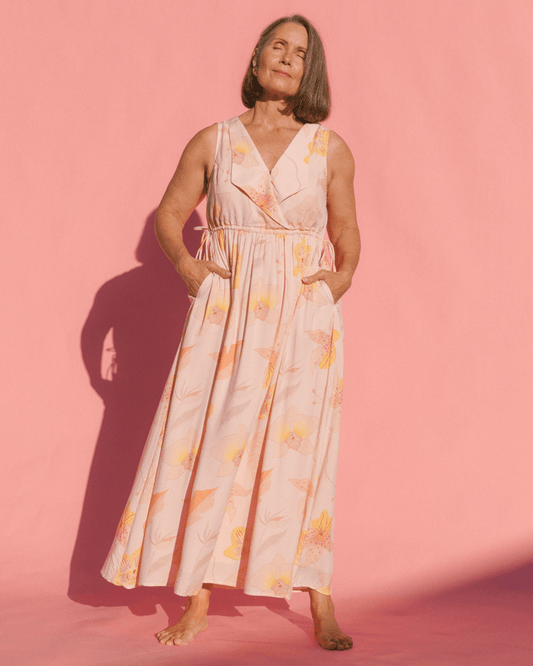 Woman wearing a floral dress against a pink background