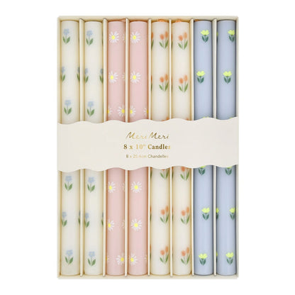 Set of 8 floral-patterned candles in pastel colors with 'Mireille Mermel' branding.