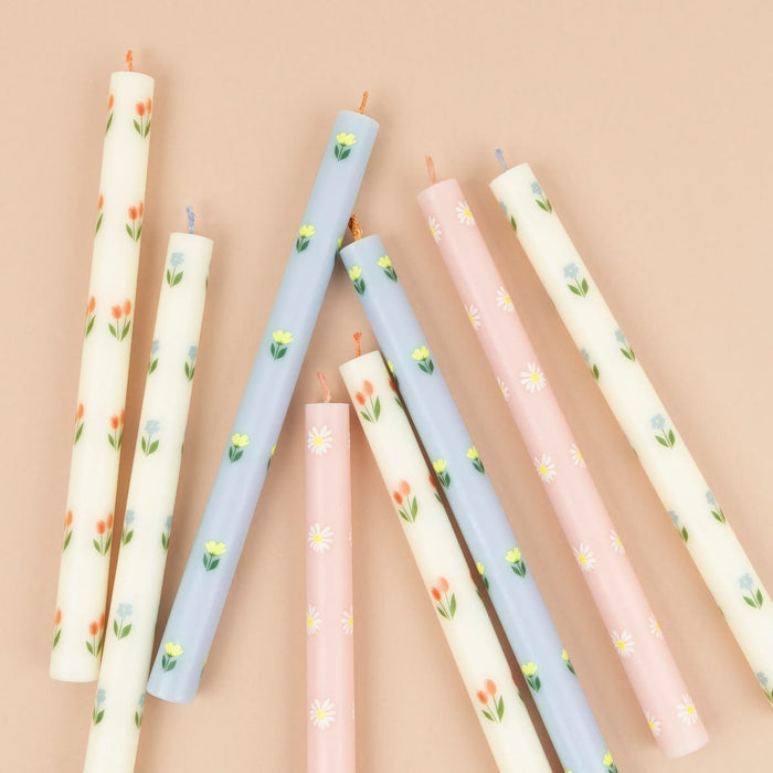 Set of decorative candles with floral patterns on a beige background