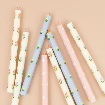 Set of decorative candles with floral patterns on a beige background