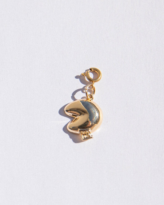Gold charm with a fortune cookie pendant on a white background