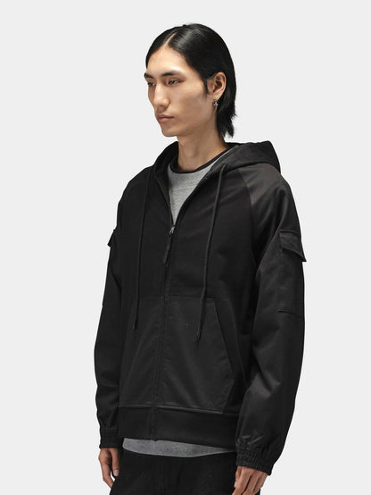 Alpha Industries M-65 Zip Up Hoodie in black over a gray shirt, featuring zip closure and hood.