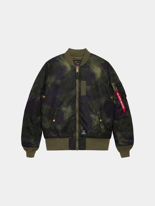 Alpha Industries MA-1 Mod Bomber Jacket in olive rd camo with camouflage print, front zipper, ribbed cuffs, side pockets, utility pocket, red Remove Before Flight tag.