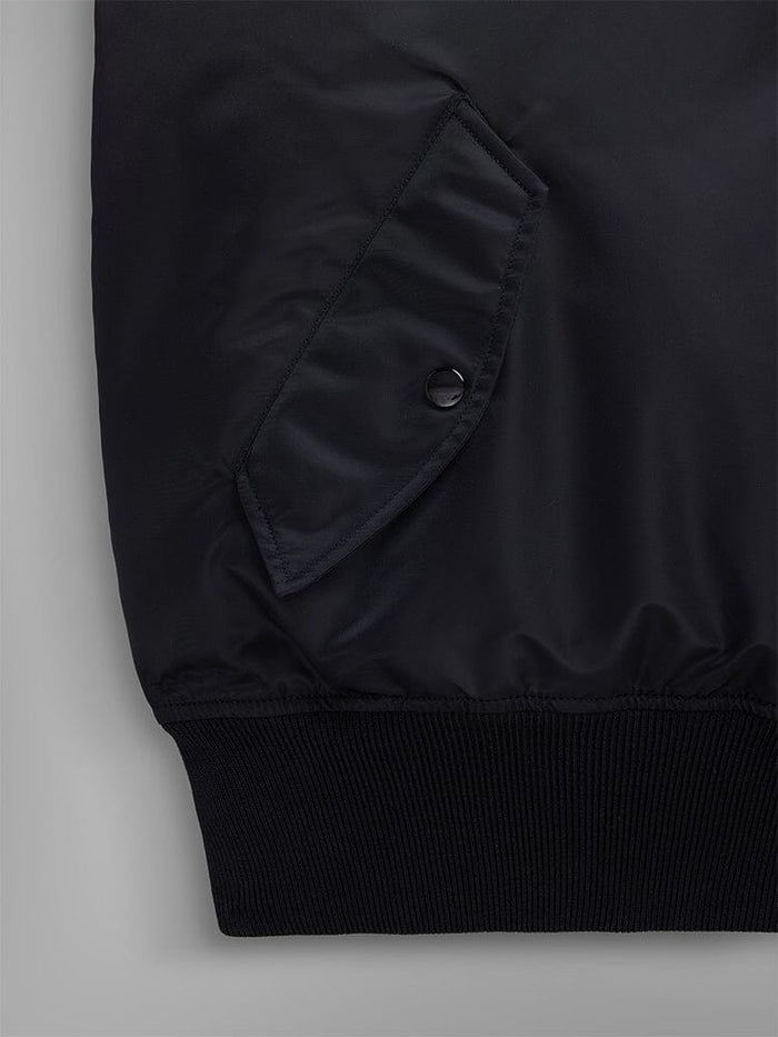 Close-up pocket view of the Pull-Over MA-1 Jacket Hoodie by Alpha Industries, showcasing its iconic black flight nylon design with a snap-button utility pocket and ribbed hem.