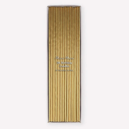 A tall rectangular box of gold birthday candles with a clear top, shown on a plain light gray background. The front has vertical gold candle sleeves and small printed text reading 'Miss Meiss 36 Birthday Candles' and 'Handmade in Germany.