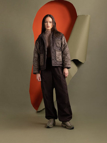 Full body view of a person wearing Alpha Industries' Women's Insulated Chore Coat in chocolate, featuring chic onion quilting.