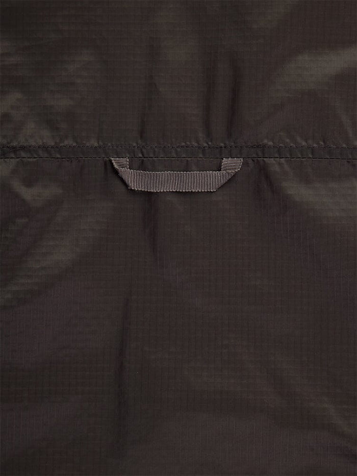Close-up back view of the Women's Insulated Chore Coat in chocolate by Alpha Industries, featuring a dark nylon ripstop fabric with a centrally located small stitched loop, reminiscent of onion quilting.